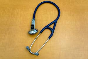 stethoscope with buttons resting on desk