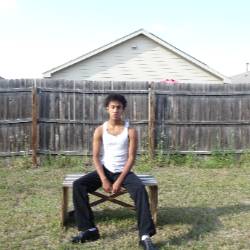 an artist sits at a picnic table in a backyard