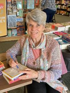 Photo of Janet McGriffin seated at a book signing. 