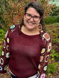 An image of a white woman in a burgundy shirt