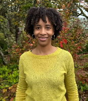 An image of an african american woman in yellow sweater