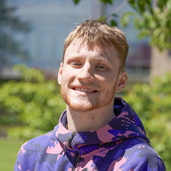 grad wearing blue and pink patterned hoodie