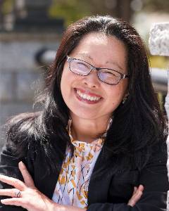 a woman with black hair smiling on the TCC Bridge