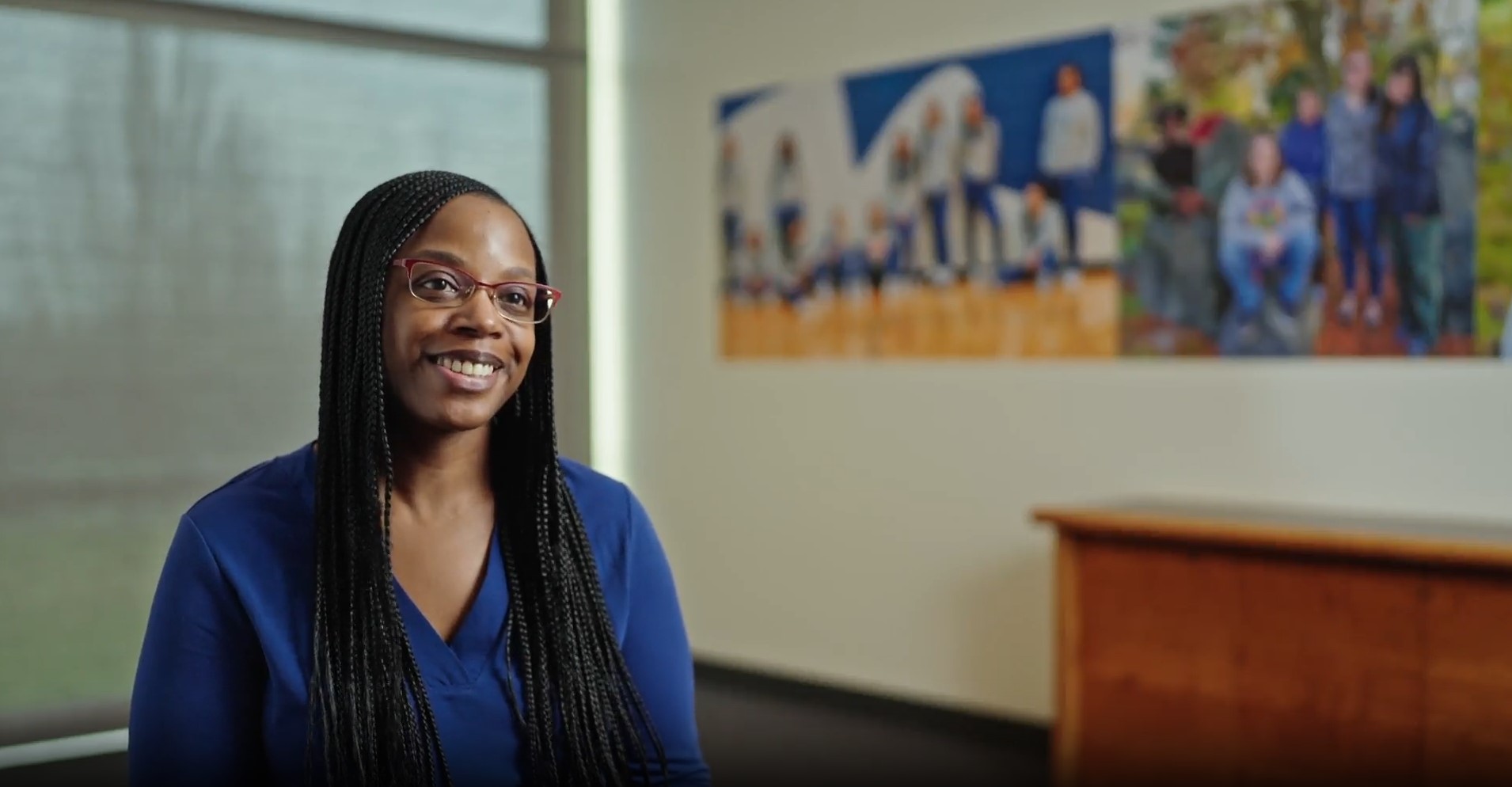 Woman smiling in glasses wearing a blue blazer