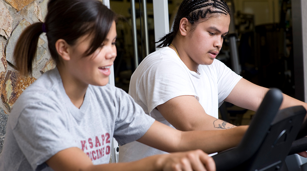 two students use an exercise bike