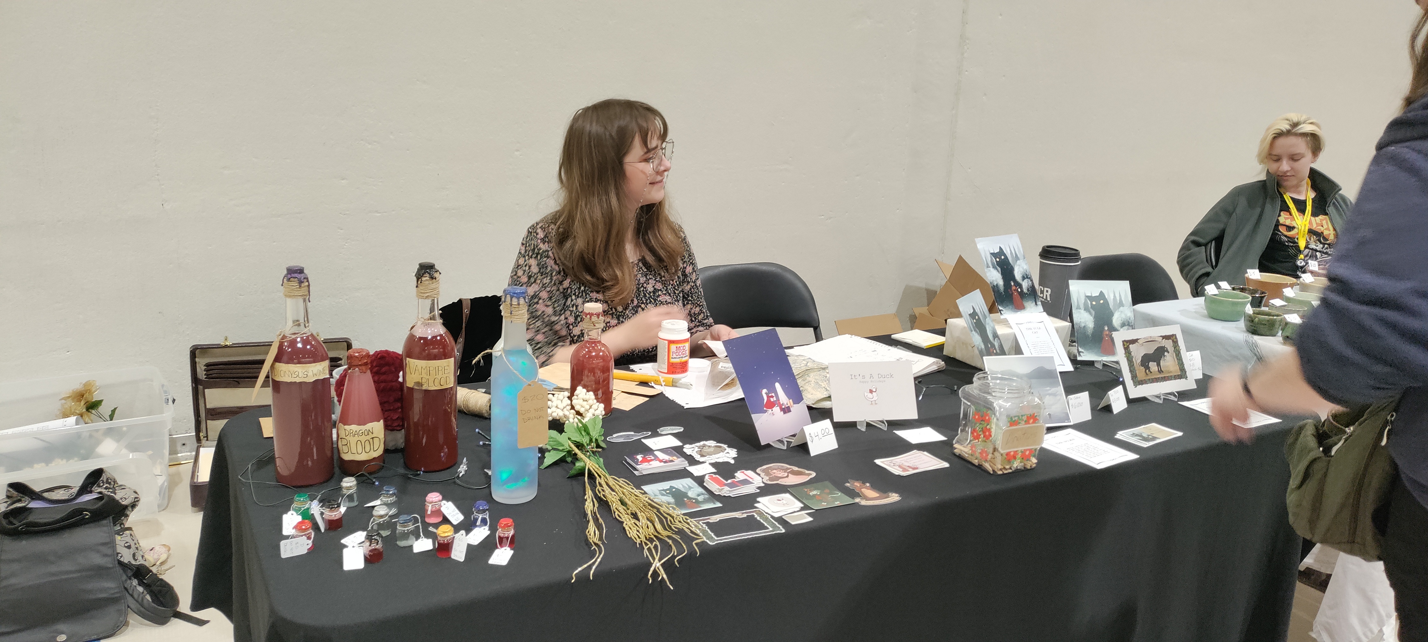 Photo of a person at a table with art. 