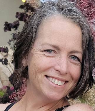 woman with short gray hair with flower background