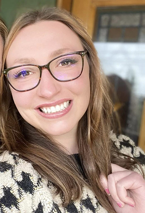 A woman in glasses smiling. 